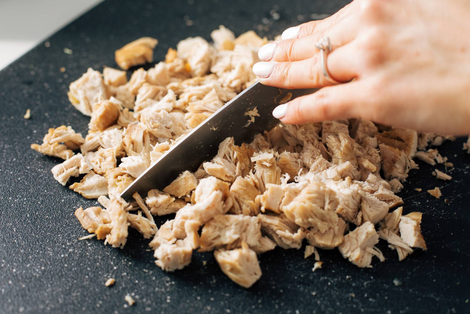 Chopped cooked chicken on a cutting board.