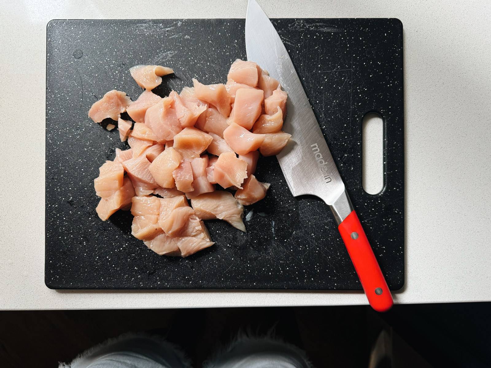Cubed chicken on a cutting board.