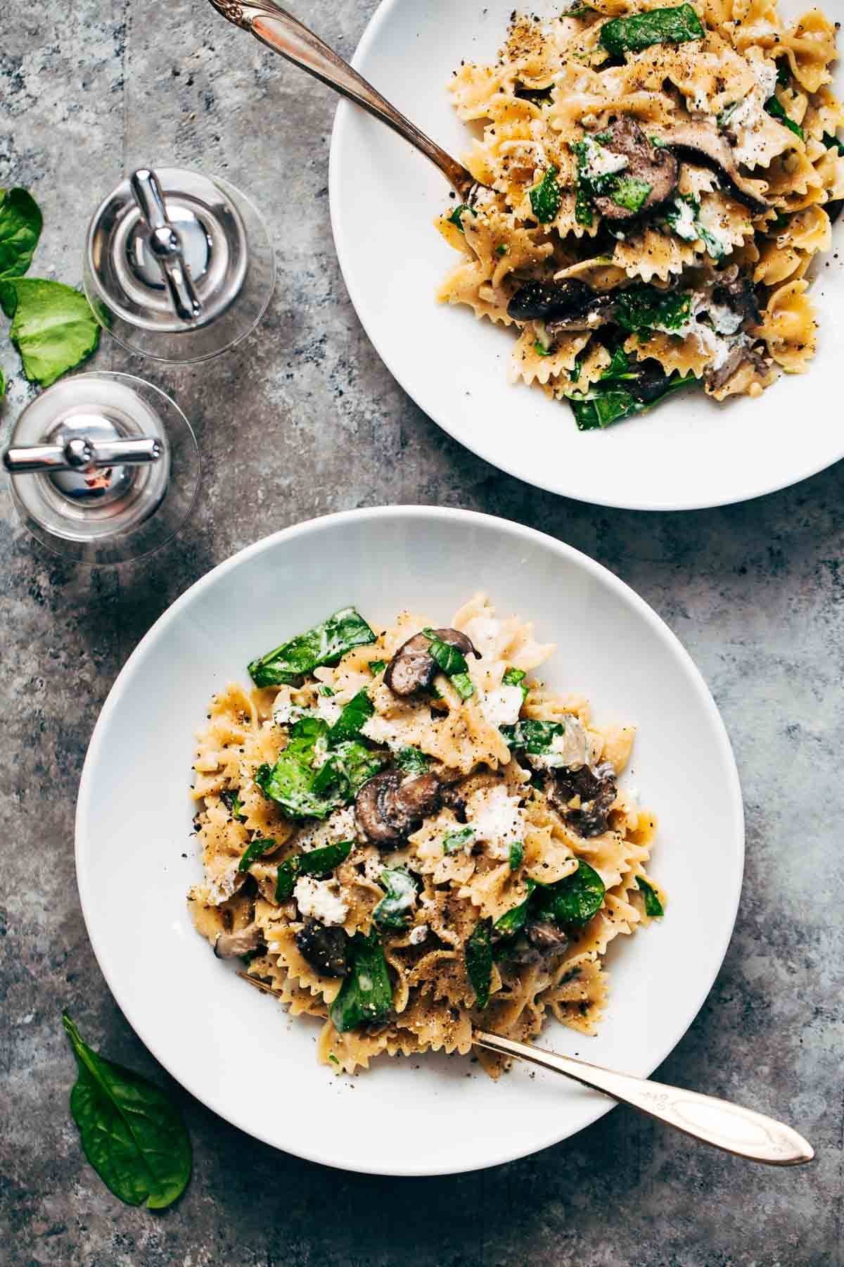 Mushroom Pasta with Goat Cheese in two white bowls with forks.