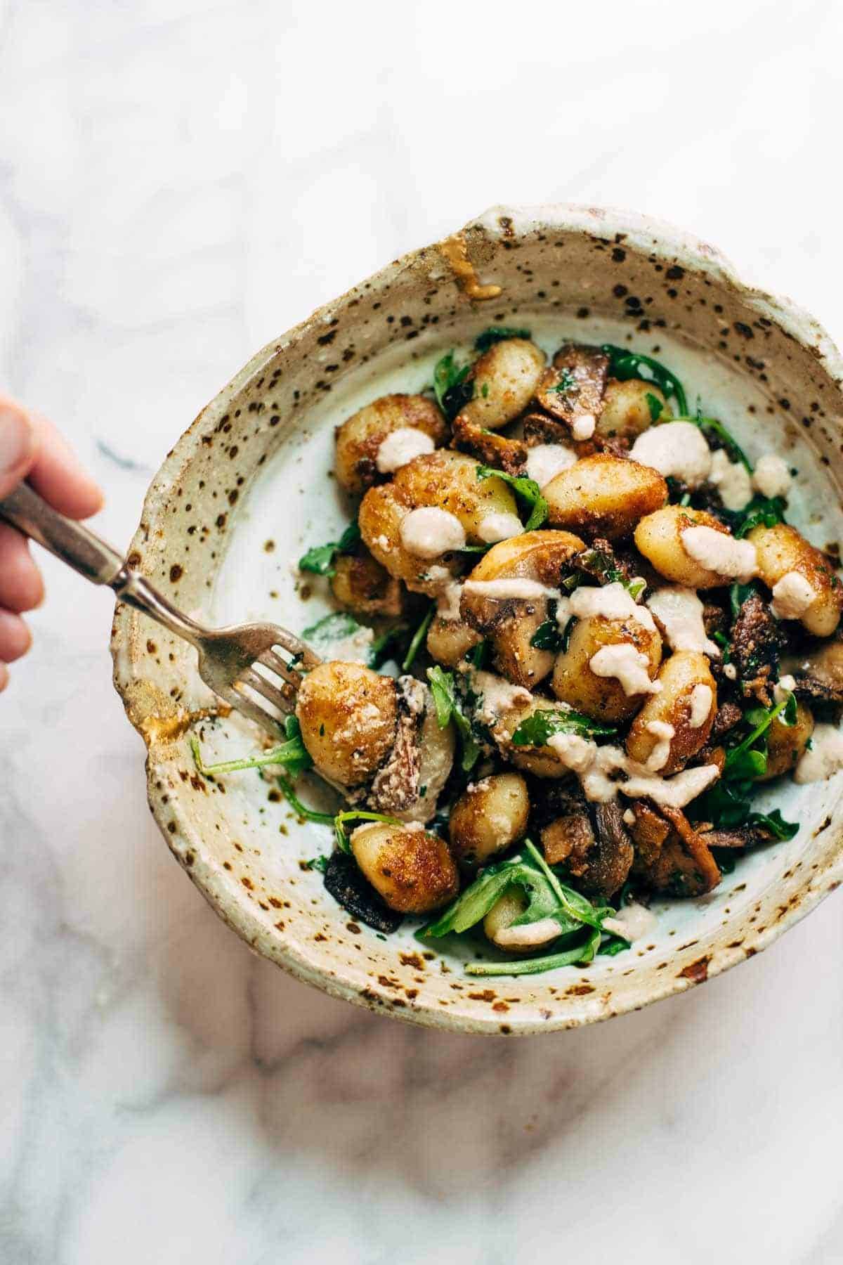 Mushroom Gnocchi with Walnut Pesto and Arugula - a vegetarian bowl that's made with familiar ingredients. Comes together in 30 minutes or less! | pinchofyum.com