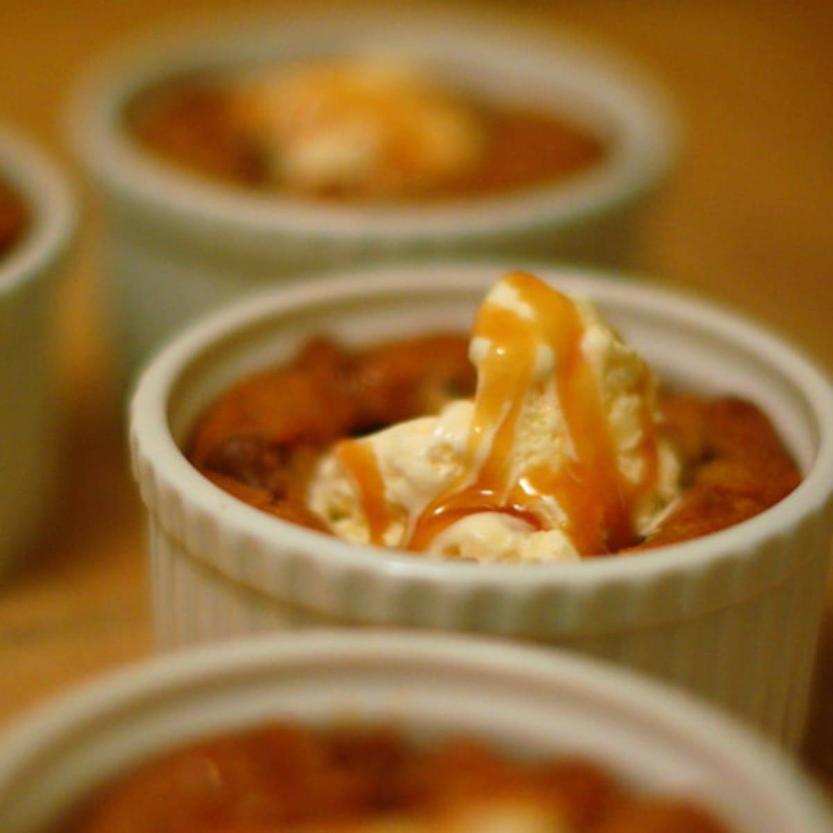 Deep Dish Chocolate Chip Cookies in small white bowls with ice cream and caramel topping.