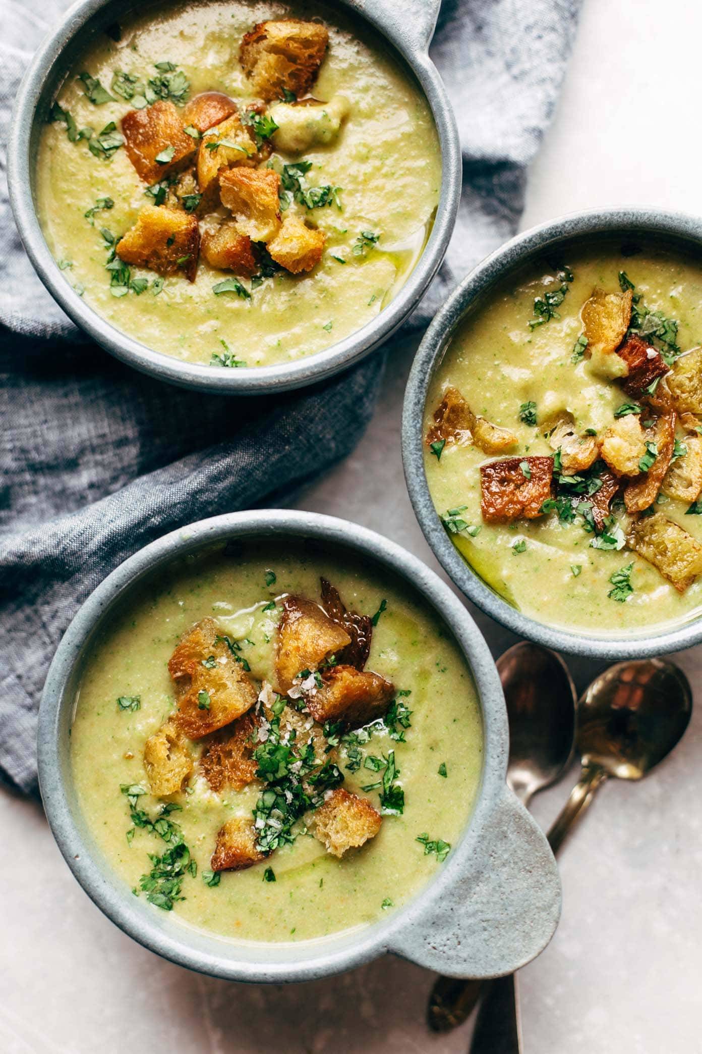Vegan broccoli cheese soup in bowls with croutons.