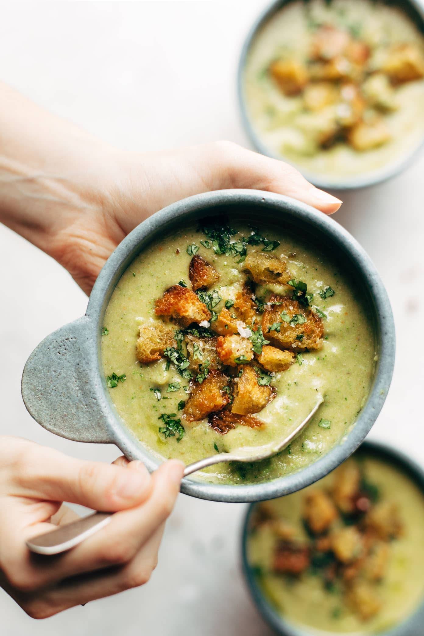 Vegan broccoli cheese soup in a bowl with a spoon.