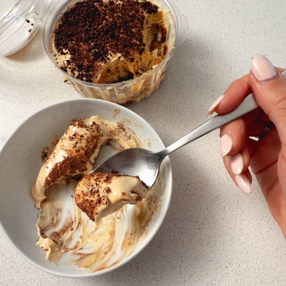 Eating tiramisu out of a bowl.