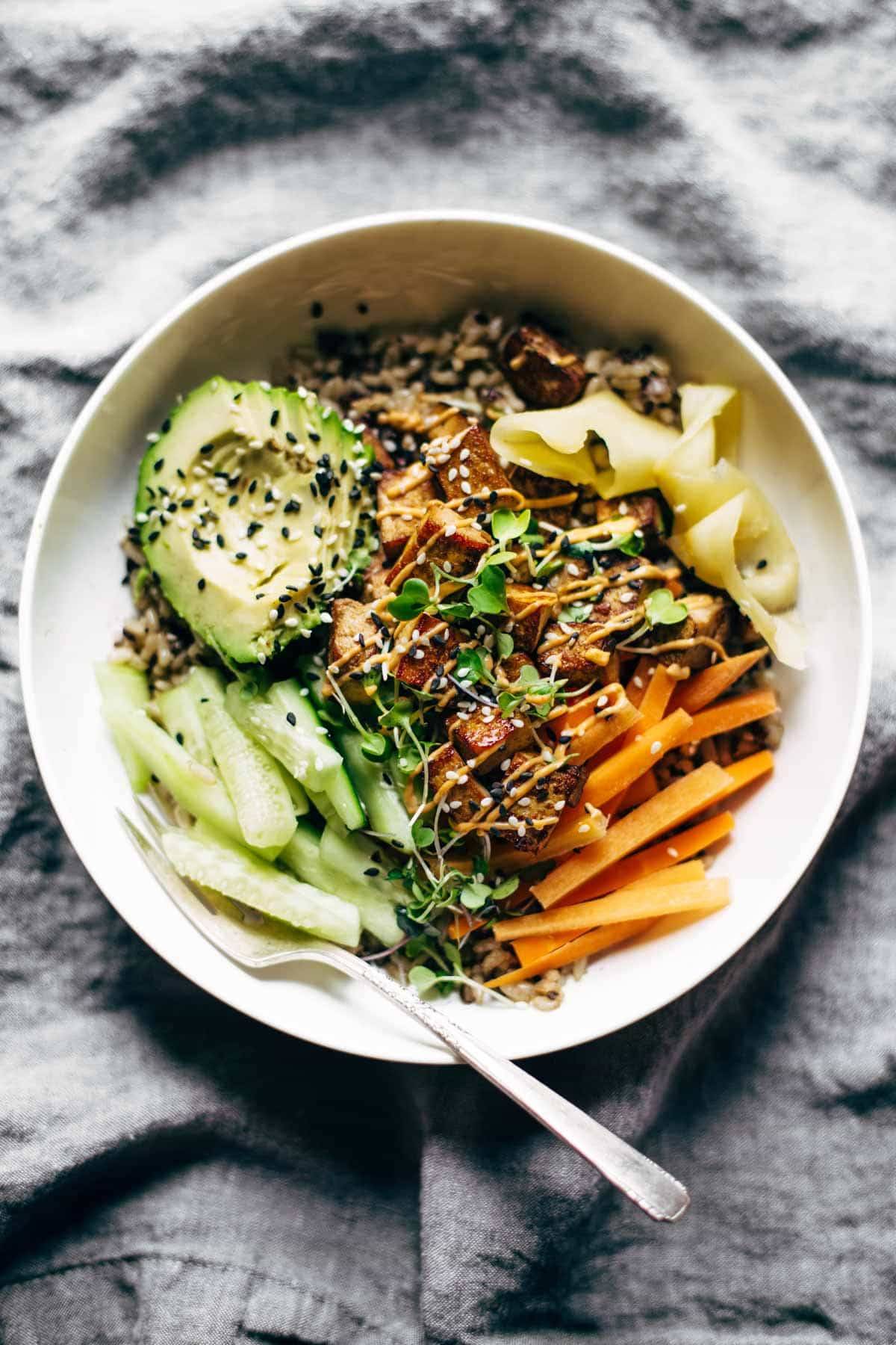 Sushi bowl on a napkin with a fork.