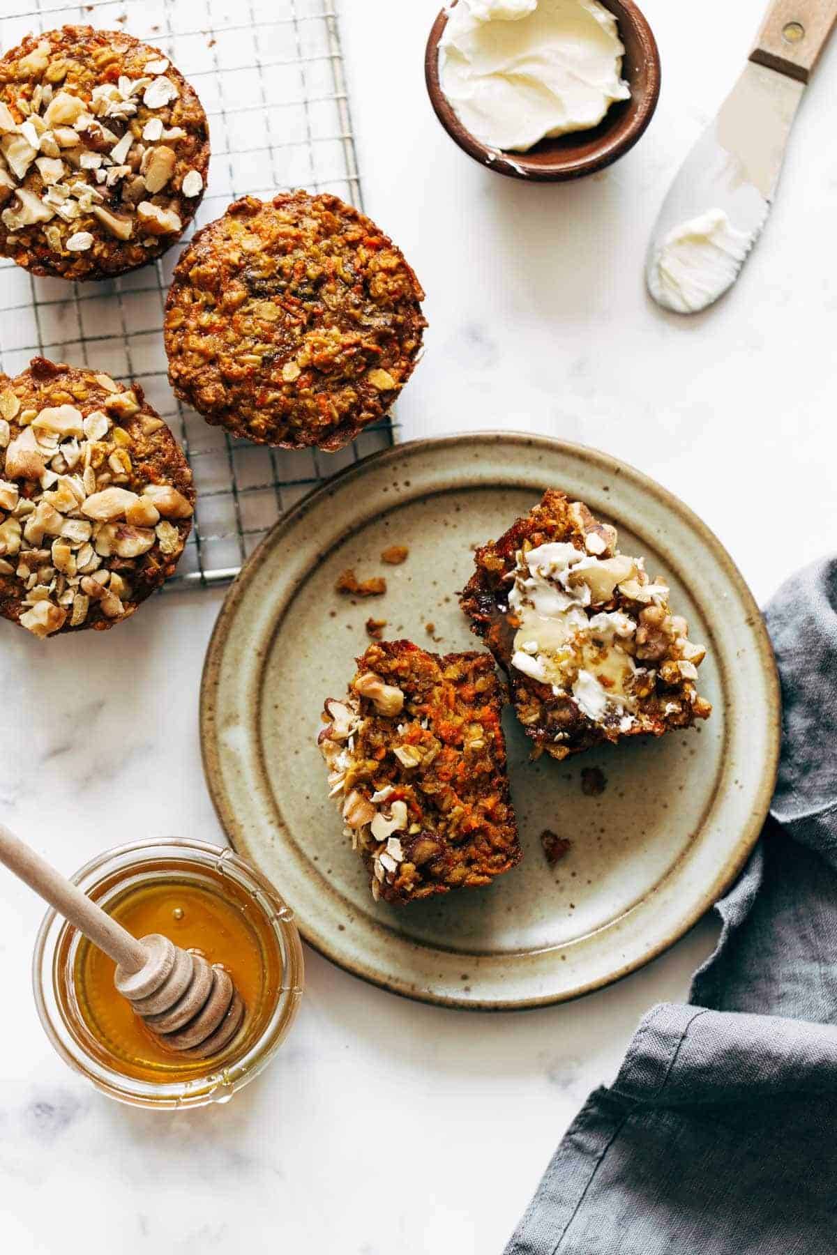 Carrot muffins on a plate with butter and honey.