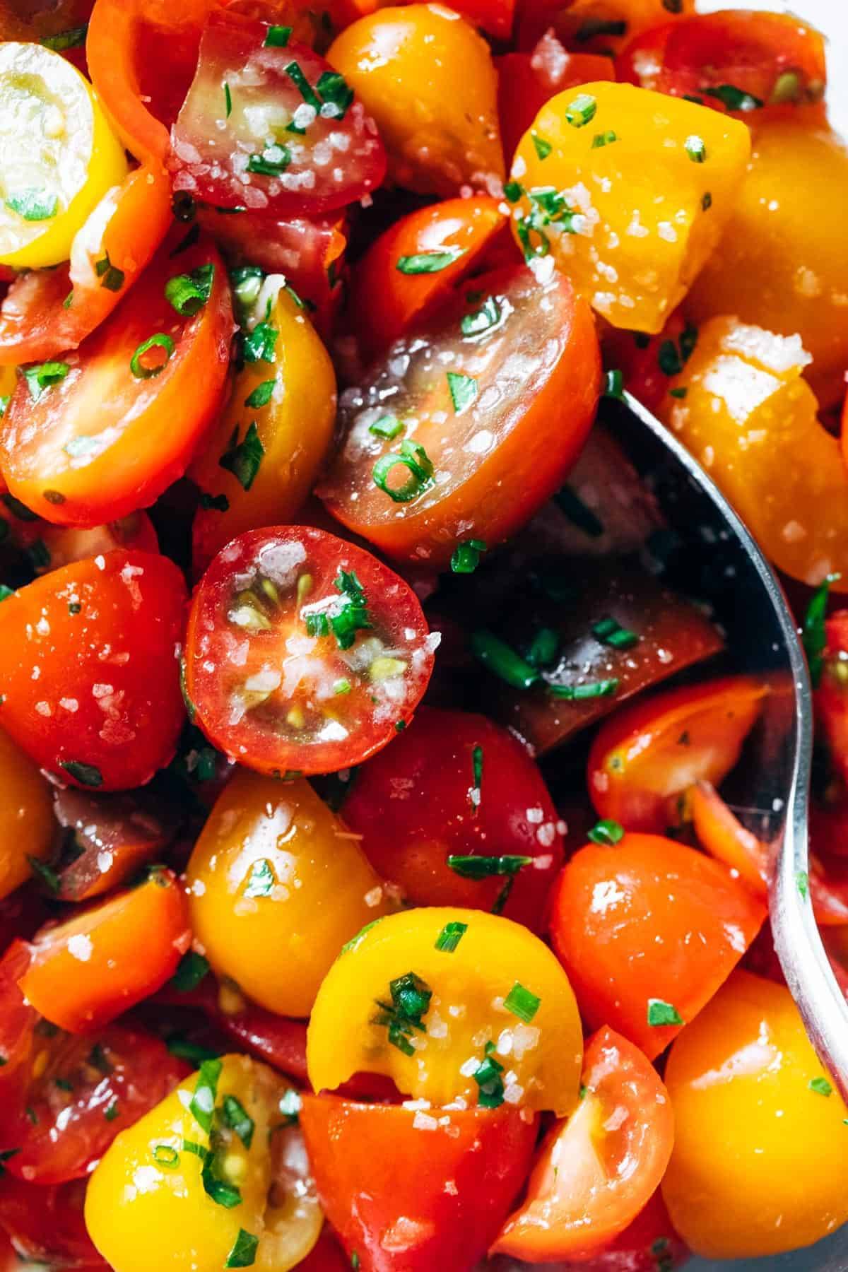 Marinated tomatoes with a spoon.