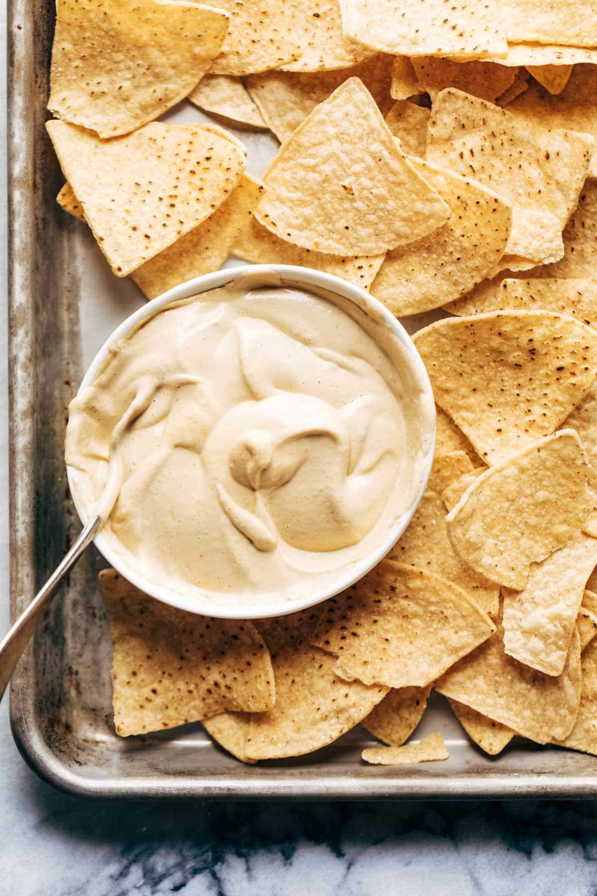 Bowl of vegan queso with tortilla chips.