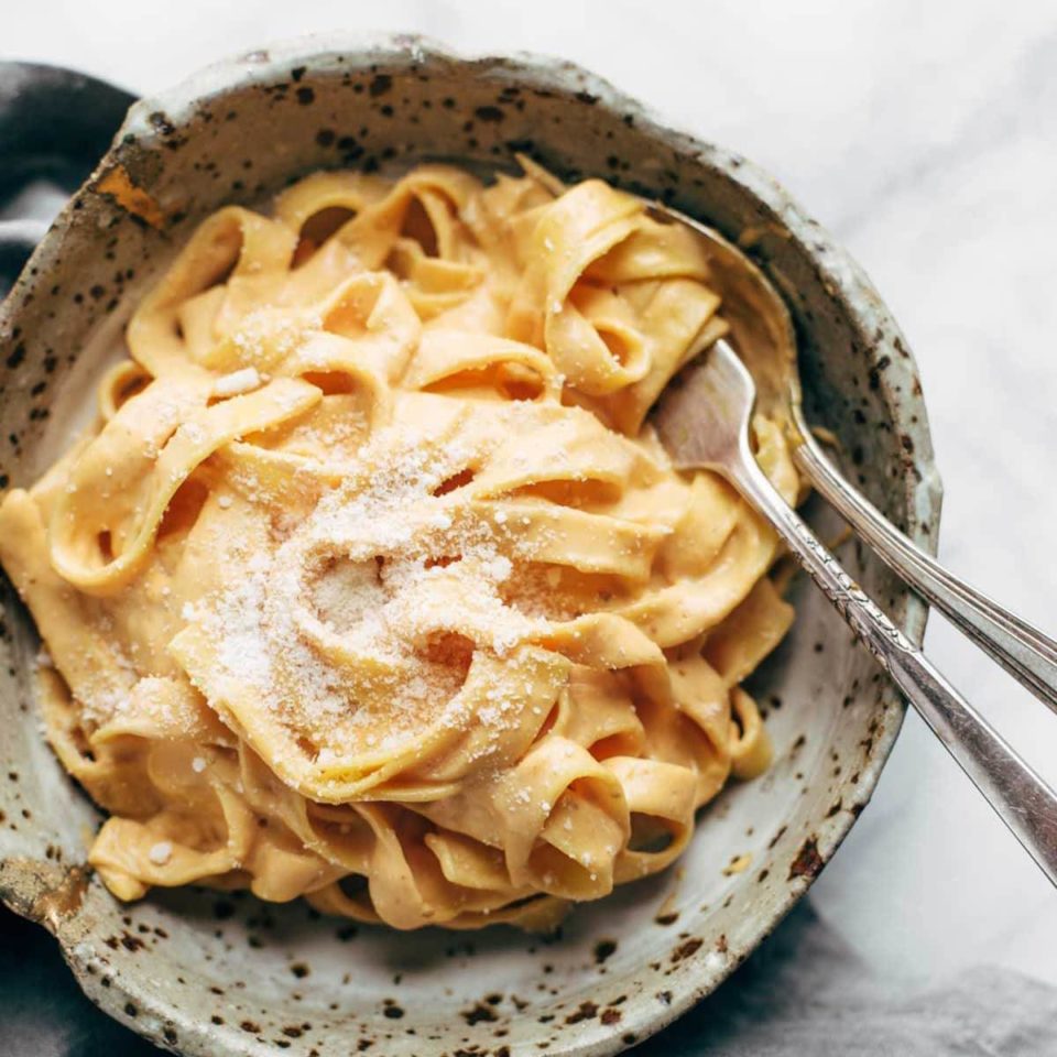Pumpkin Alfredo in a bowl with fork and spoon.