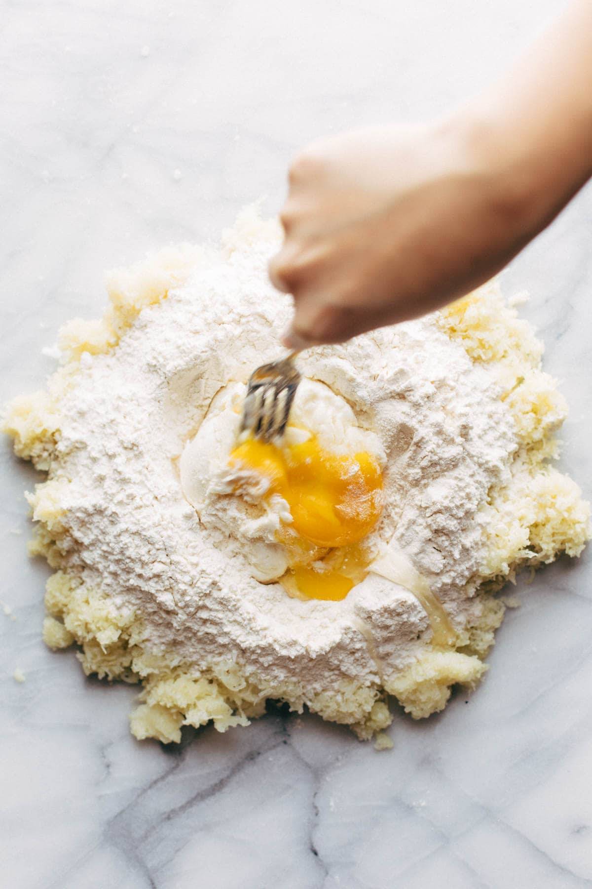 Mixing potato, flour, ricotta and eggs with fork.