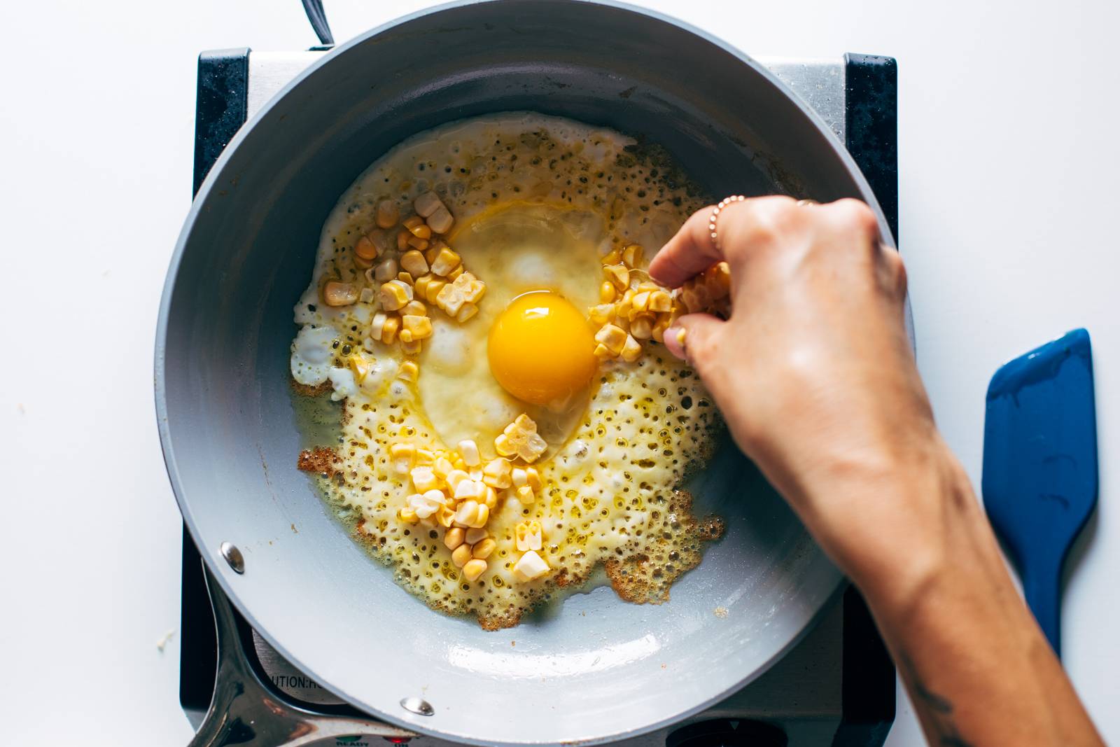 Adding corn to the egg and cheese.