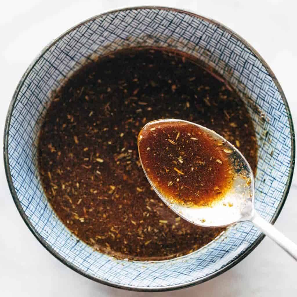 Everything marinade in a bowl with a spoon.