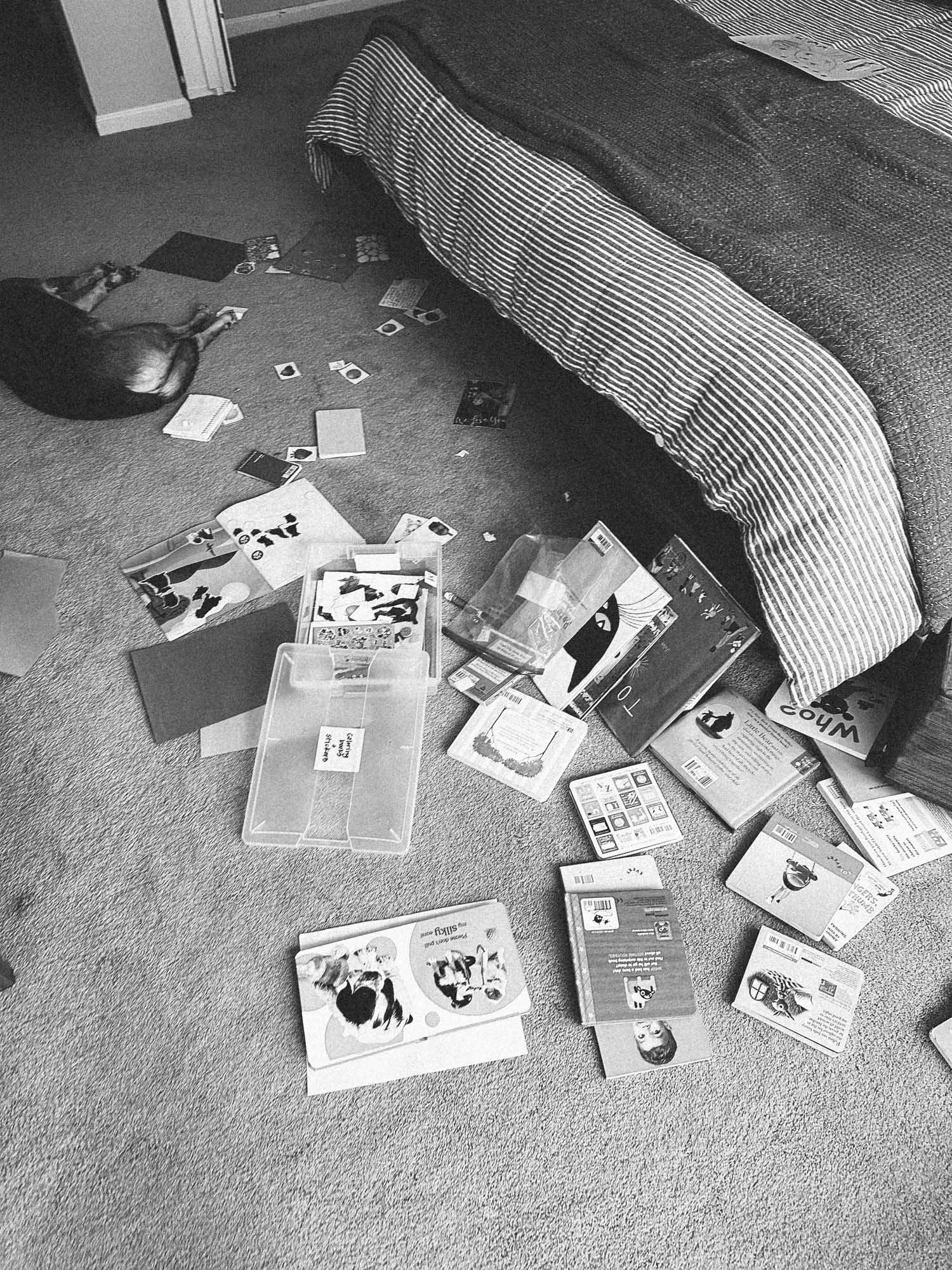 Black and white photo of stuff on the floor in a bedroom
