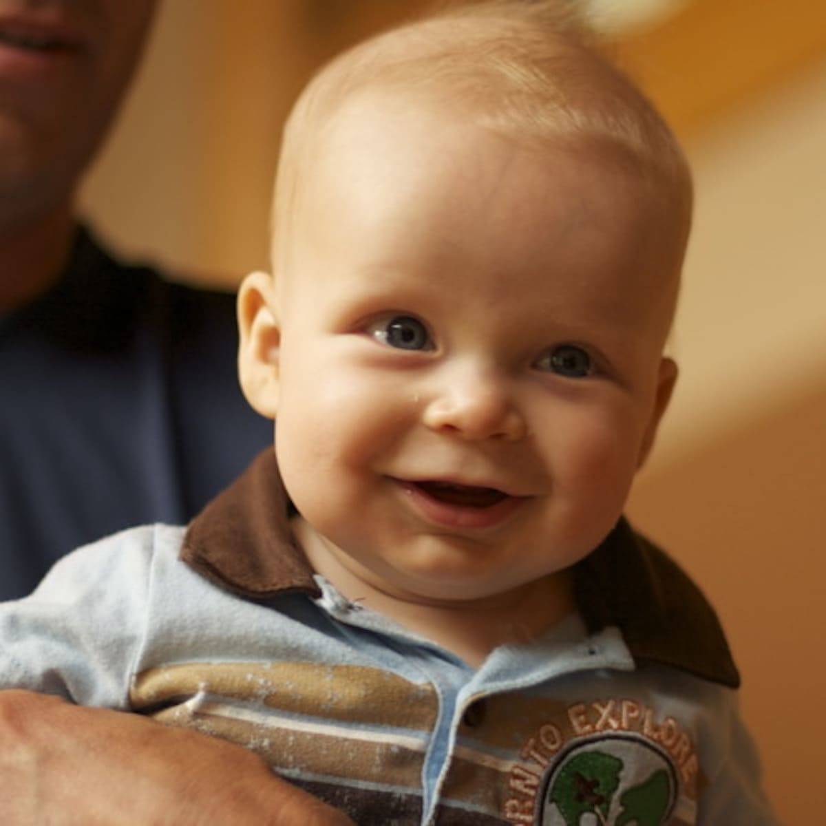 Infant boy smiling at the camera.