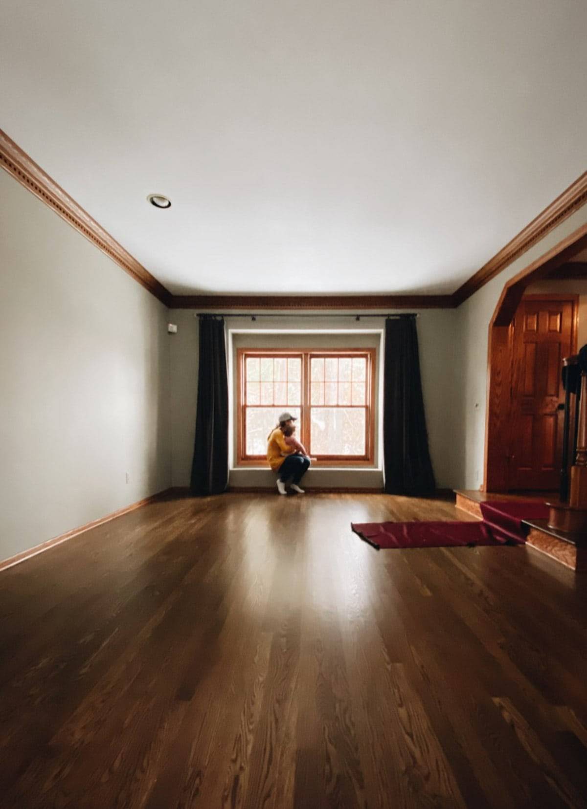 A person sitting on the far end of an empty room.