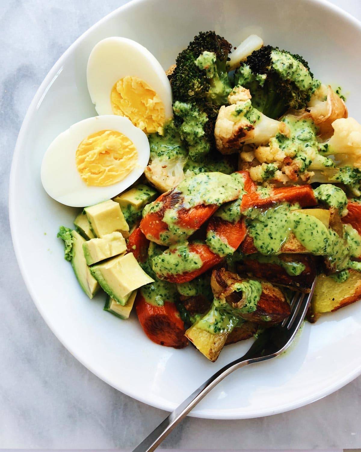 Roasted veggie bowls in a bowl with a fork.