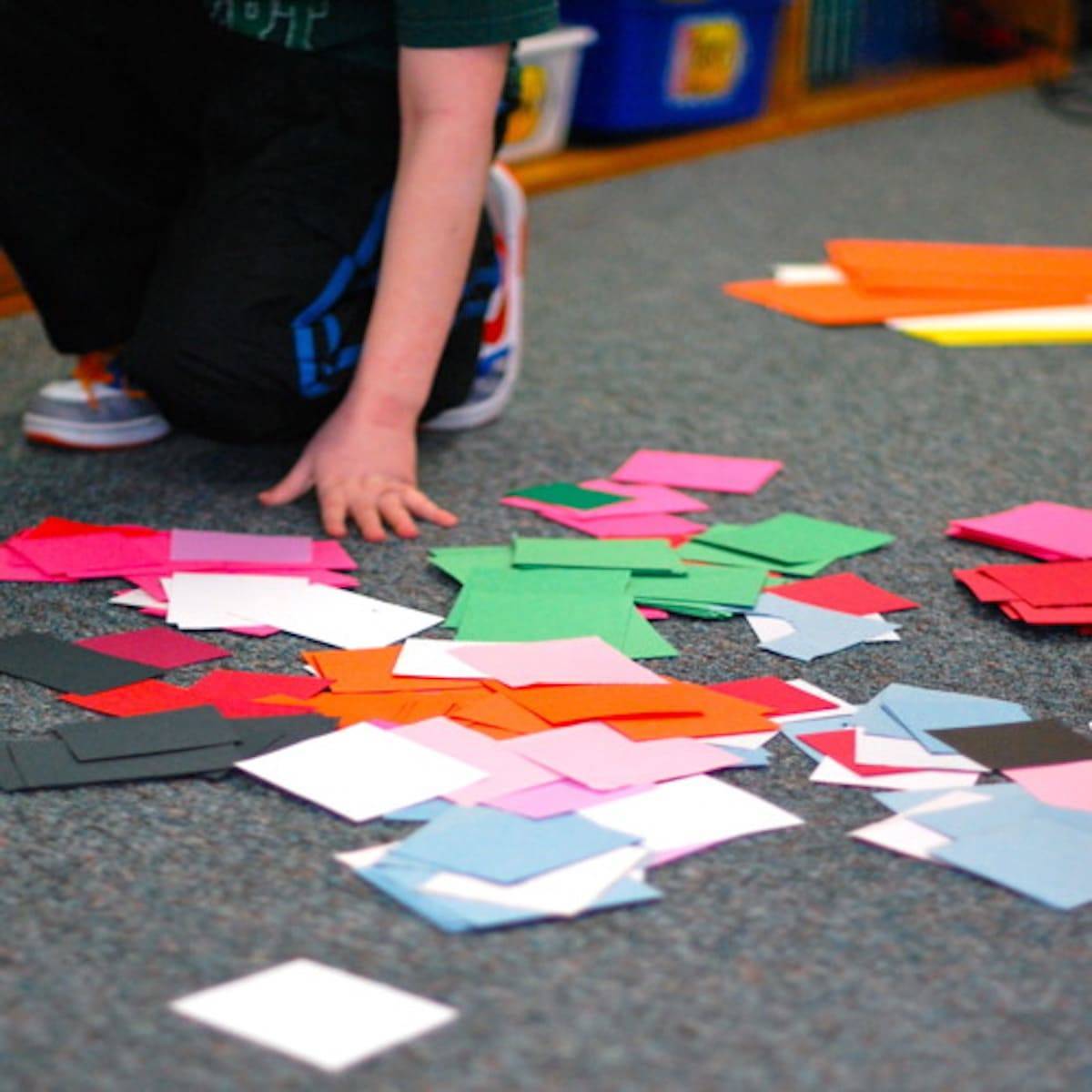 Colorful paper spread on a floor in a classroom.