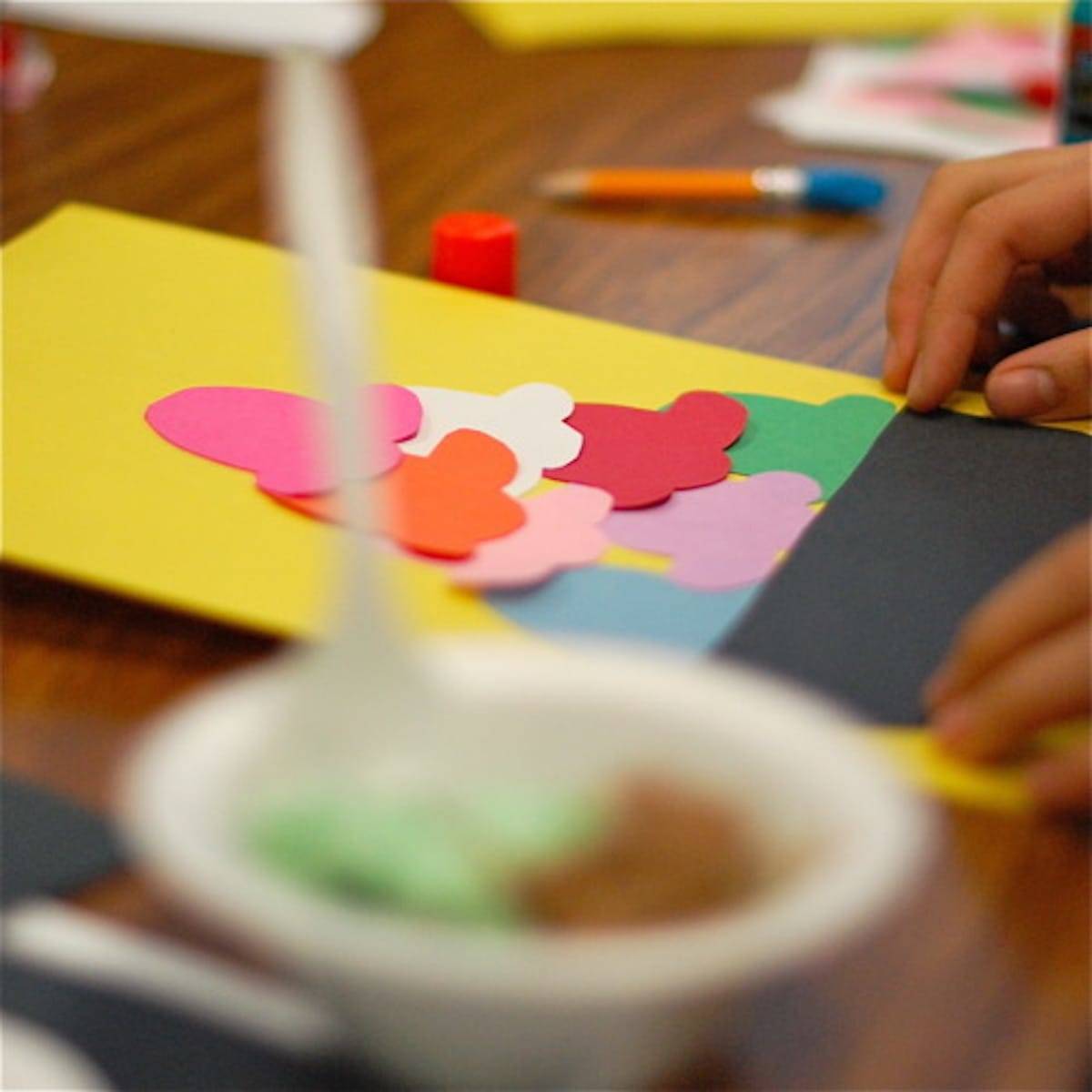 Paper ice cream cutouts on a wooden table in a classroom.