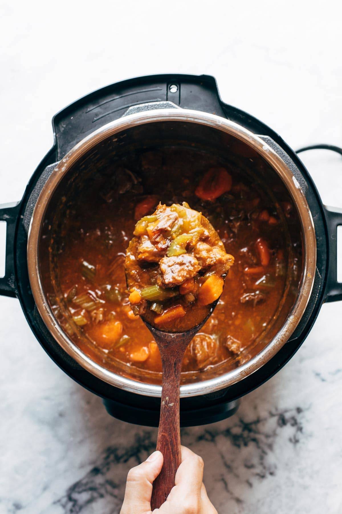 A pot with a beef stew with vegetables in it.