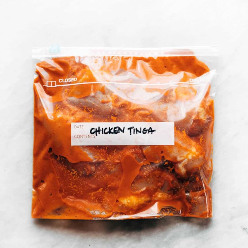 A transparent packet full of chicken tinga and with a label written over it.
