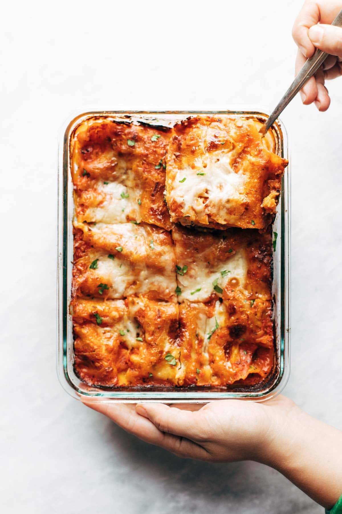 Freezer Meal Lasagna Florentine in a dish being cut into.