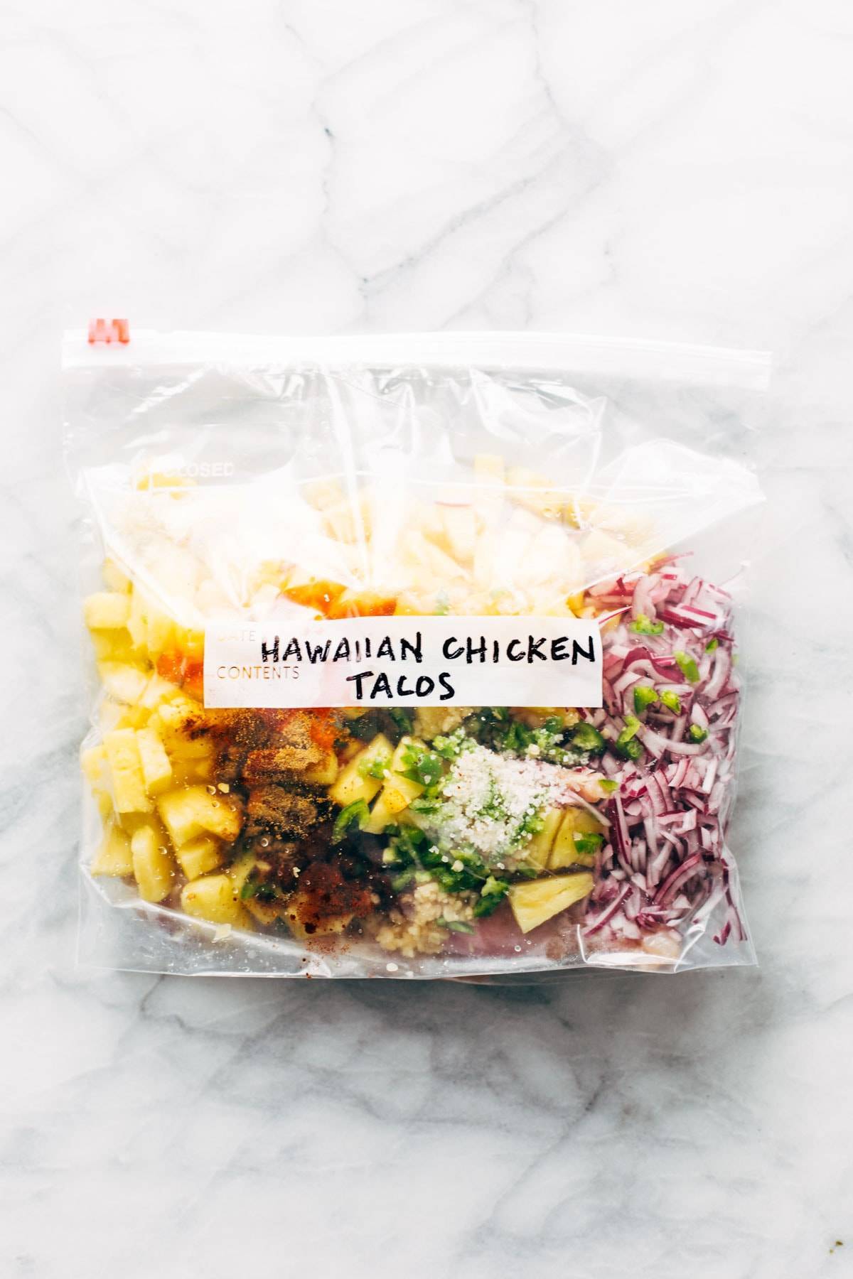 A clear bag with food and the label "Hawiian Chicken Tacos."