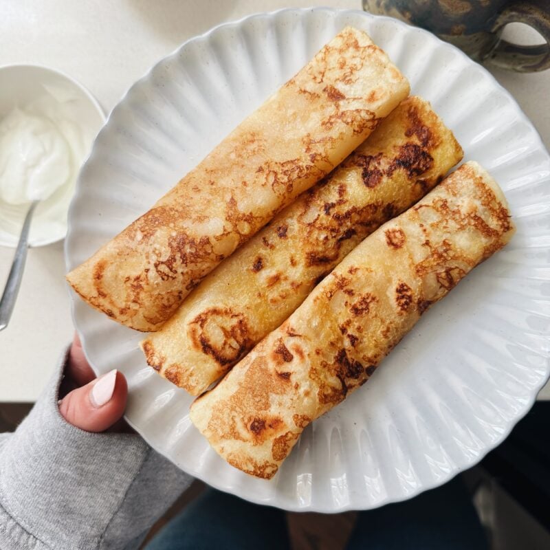 French toast crepes rolled on a plate.