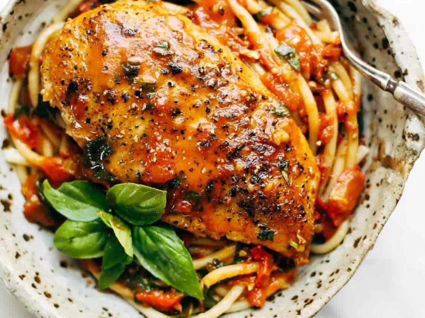 Garlic Basil Chicken in a bowl with pasta and basil.