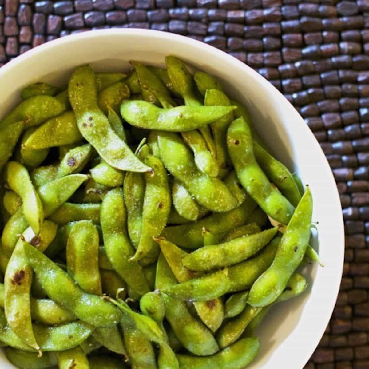 Garlic edamame in a white bowl.