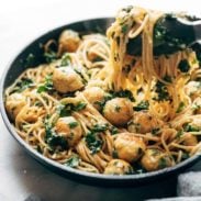 Garlic Herb Spaghetti with Baked Chicken Meatballs in a pan with noodle pull.