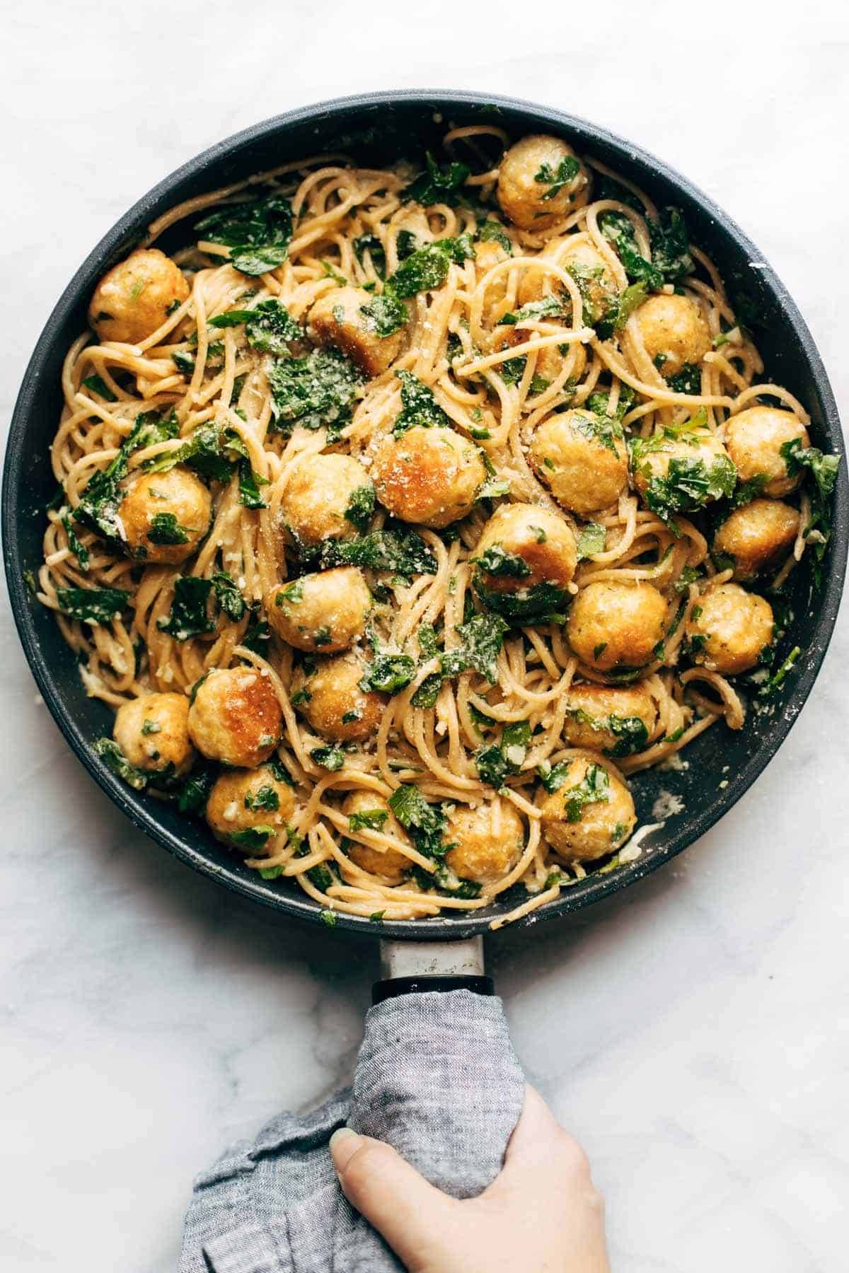 Garlic herb spaghetti and meatballs in a pan.