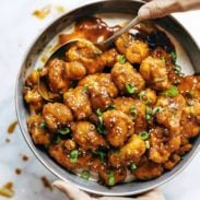 General Tso's Cauliflower in a pan with a spoon.