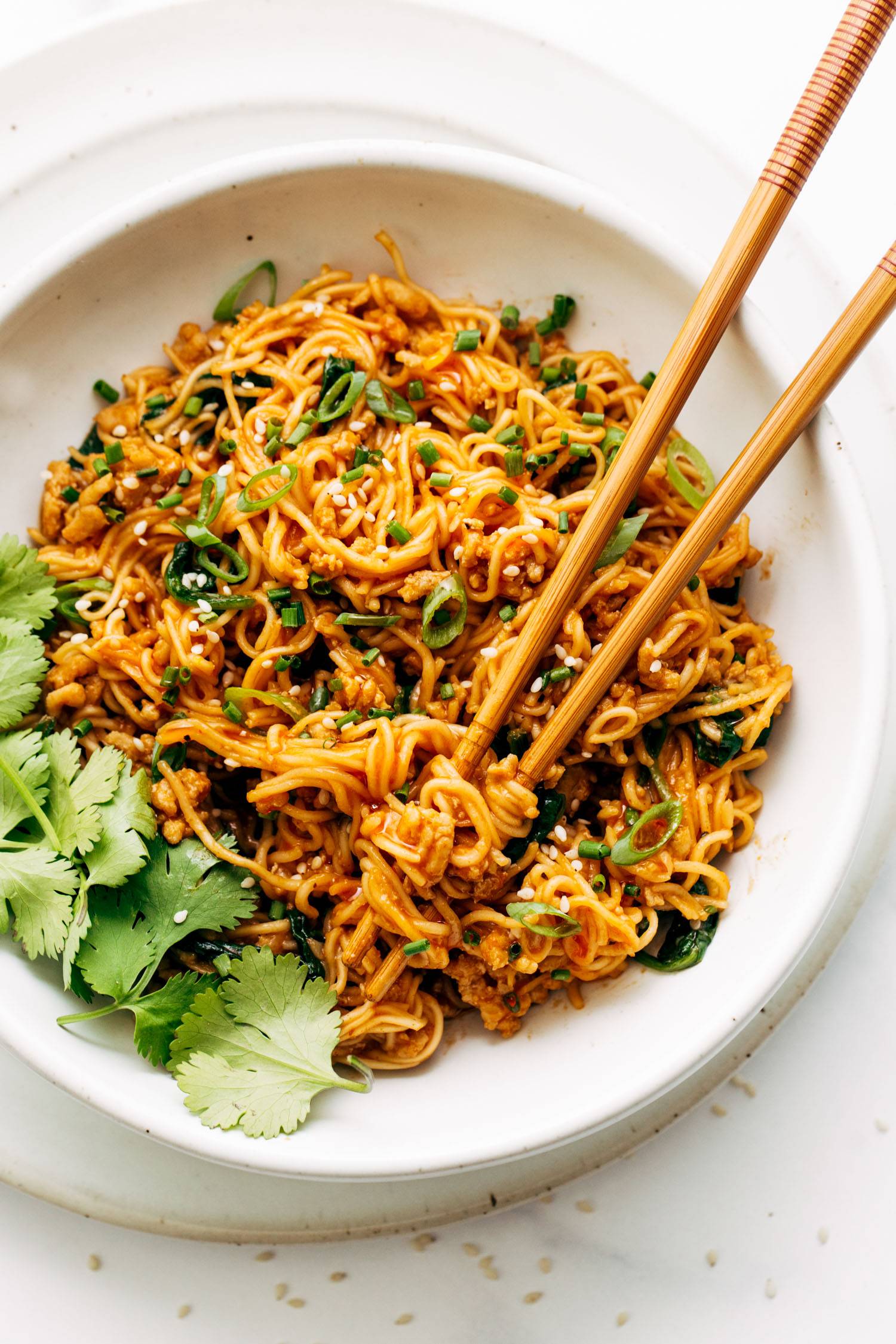 Bowl of gochujang noodles with chopsticks.