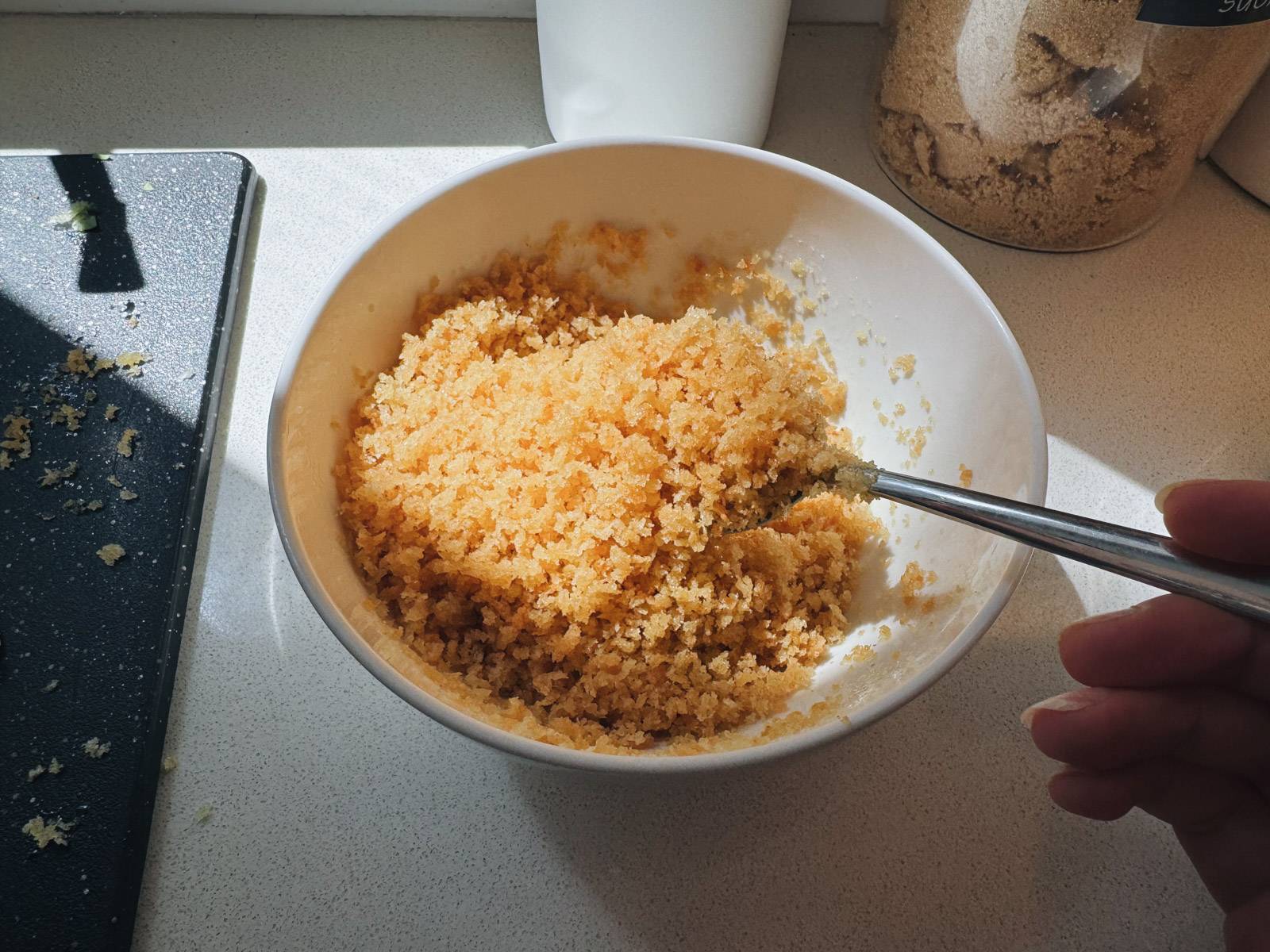 Mixing breadcrumbs in a bowl to make crispy panko topping.