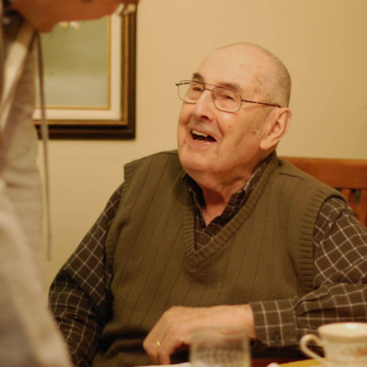 Elderly man laughing.