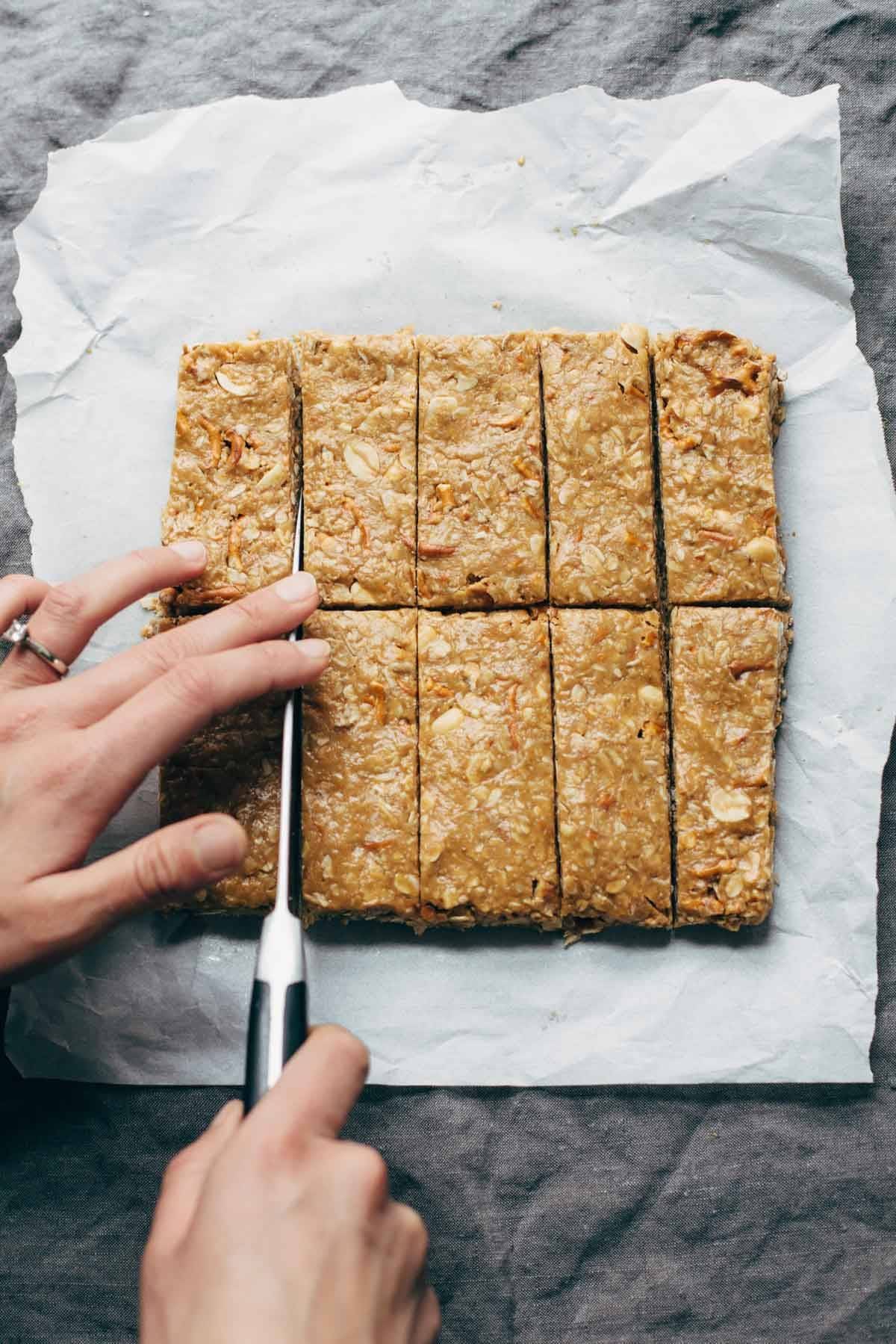 Granola bars on parchment paper cut with a knife.