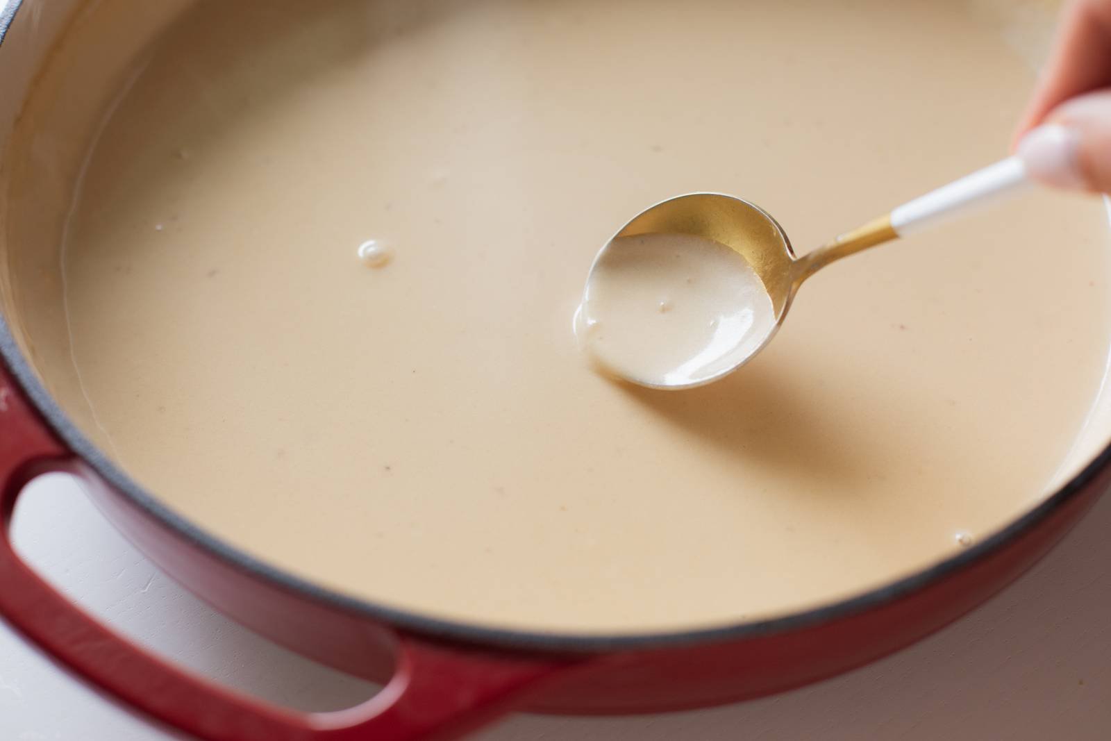 Spooning gravy in a pan.