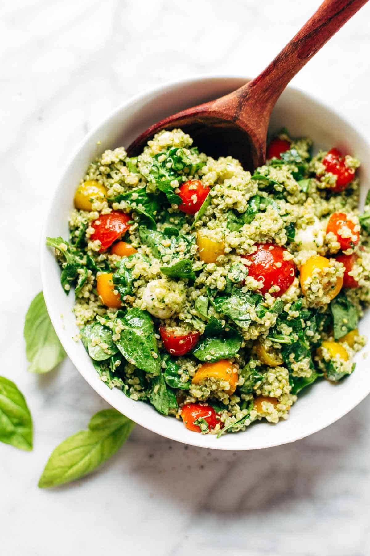 Green Goddess Quinoa Summer Salad in a bowl with a wooden spoon