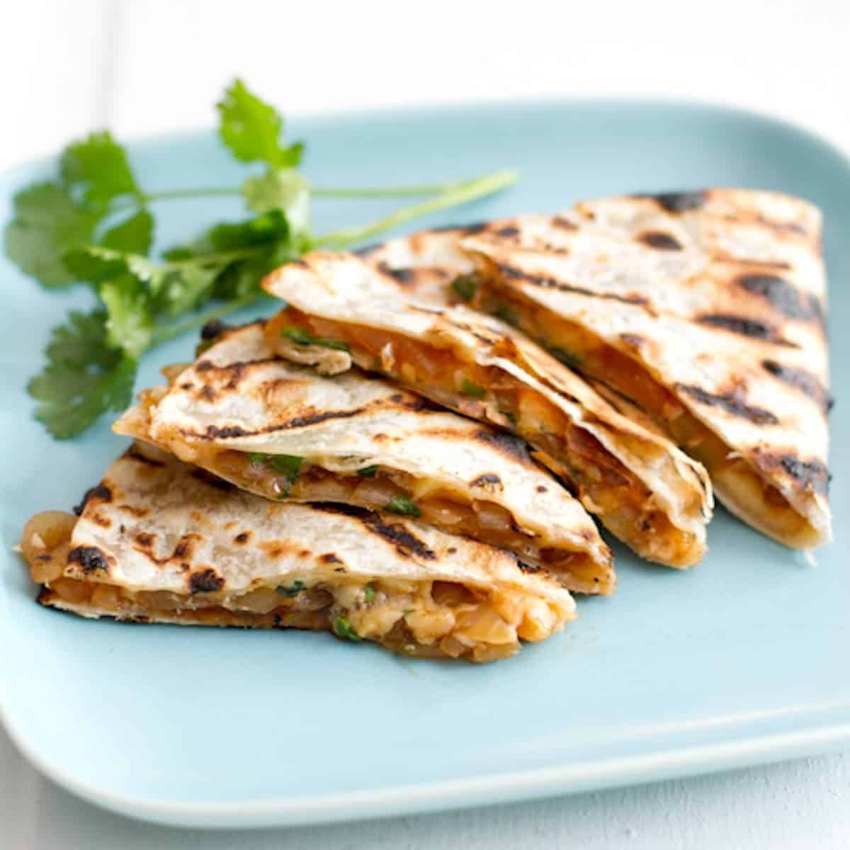 Barbeque and smoked gouda quesadillas on a blue plate.