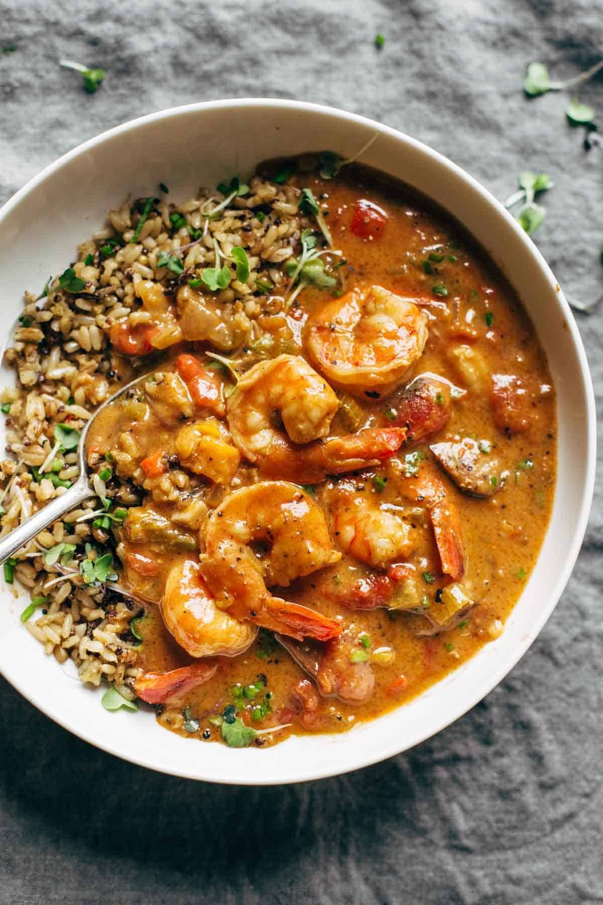 Gumbo shrimp in a bowl with rice and a spoon.