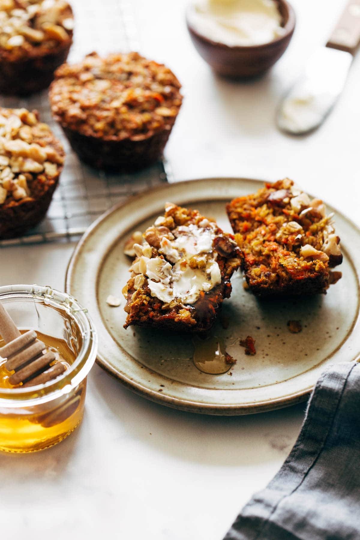 Carrot muffins on a plate with honey and butter.