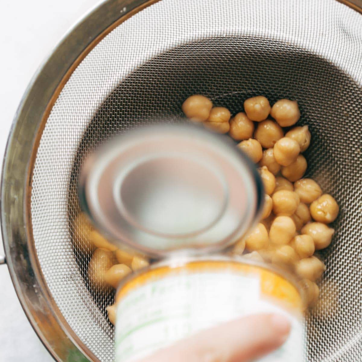 Pouring chickpeas into strainer.