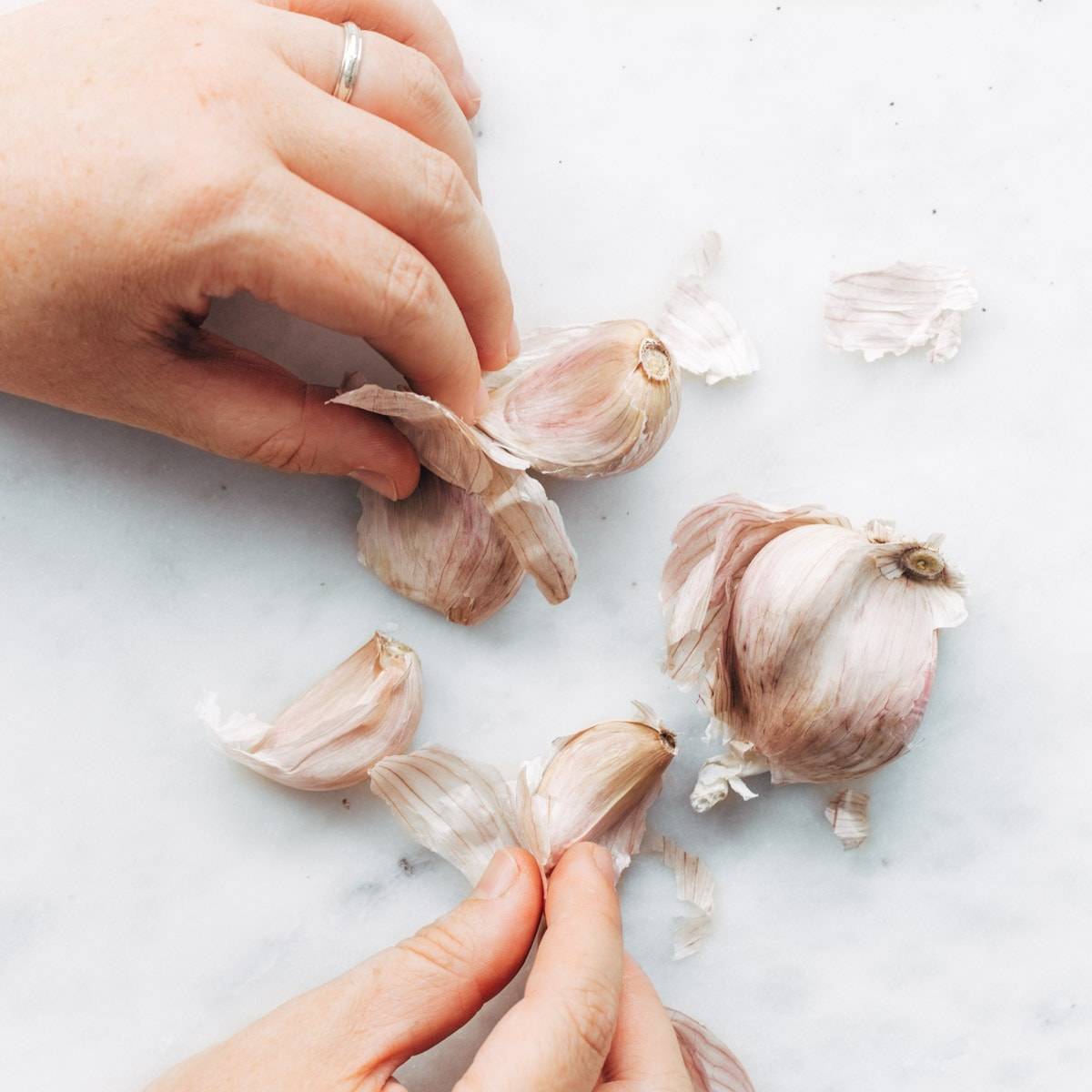 Cloves of garlic being peeled.