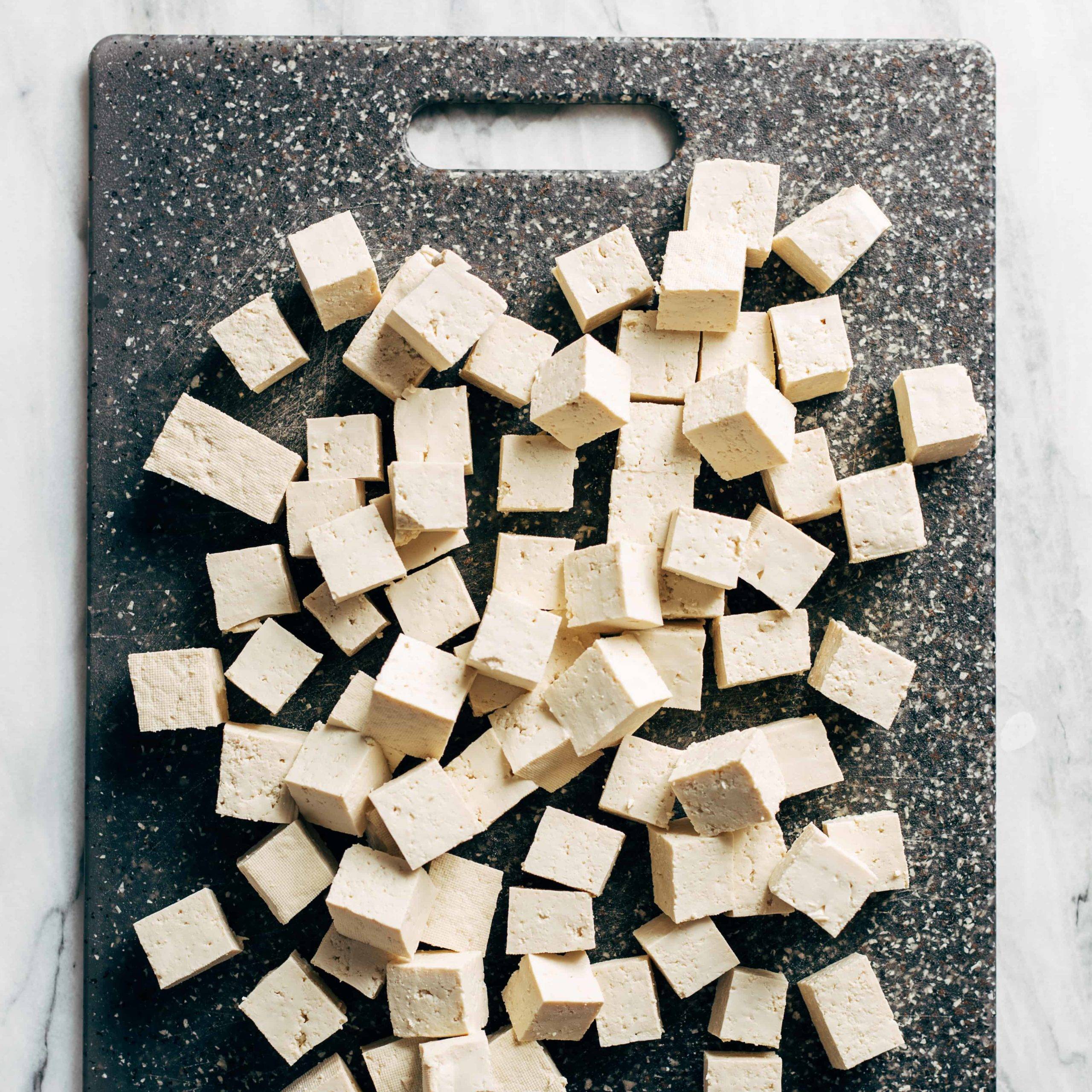 Cubed tofu on a cutting board.