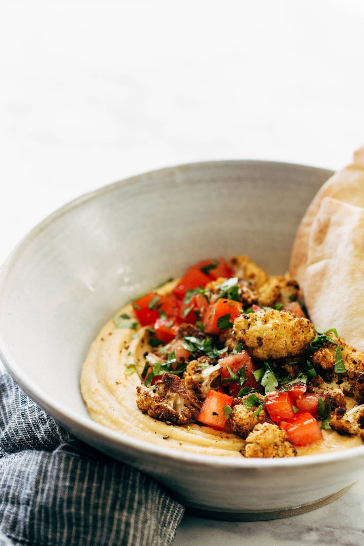 Hummus with roasted cauliflower in a bowl.
