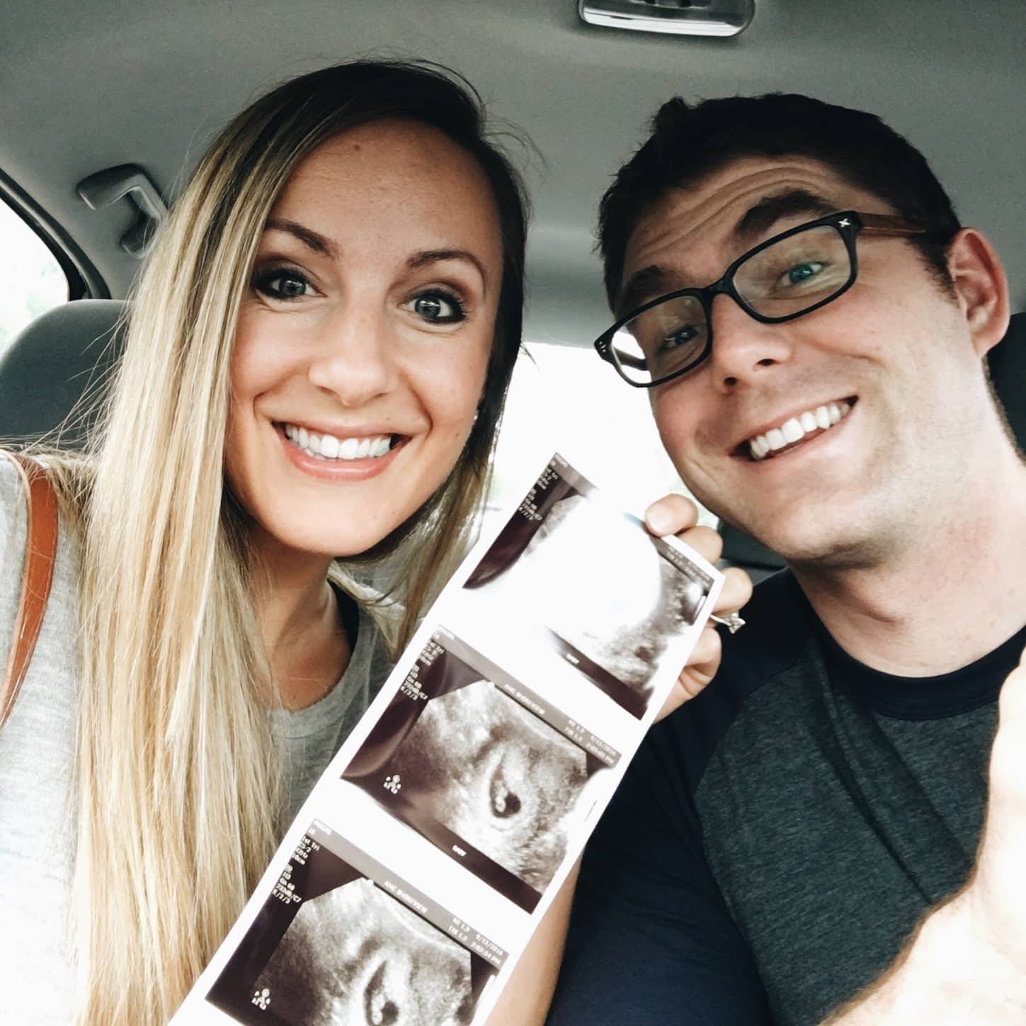 A man and a woman holding ultrasound photos.