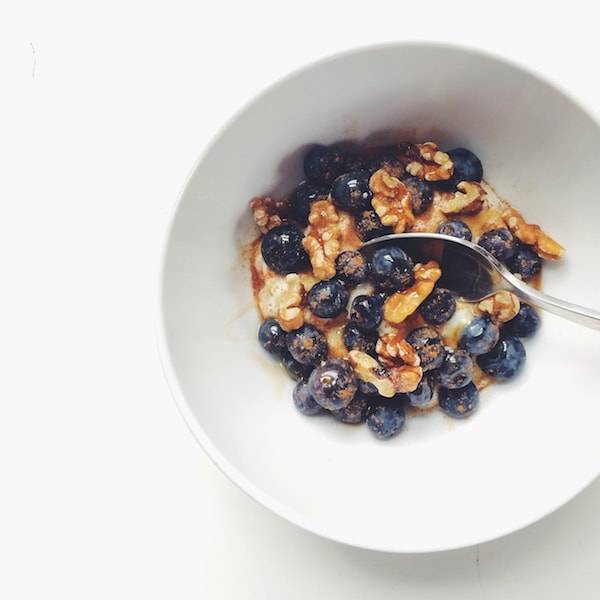Blueberries in a white bowl over oats.