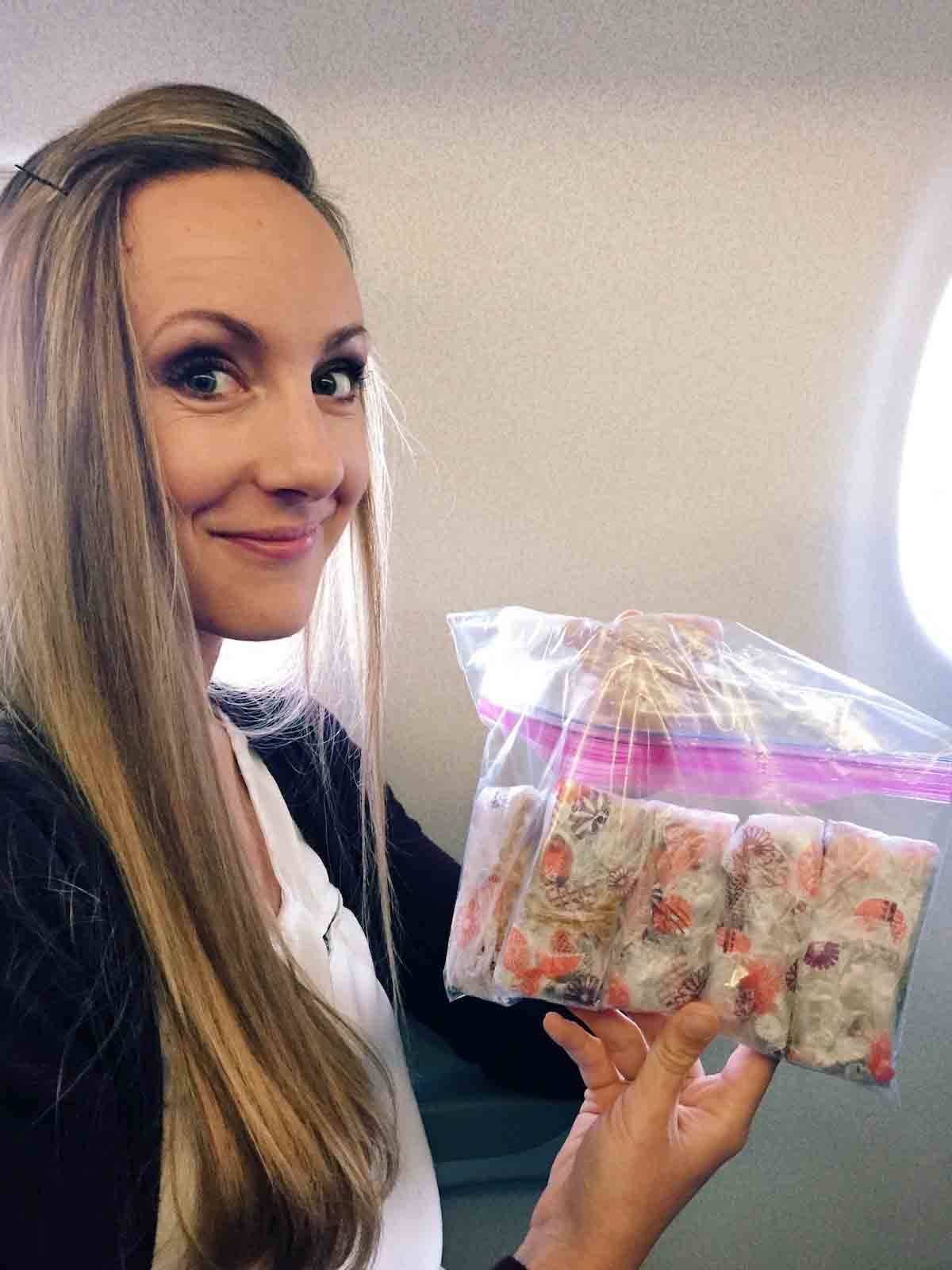 Woman holding a bag of granola bars on an airplane.