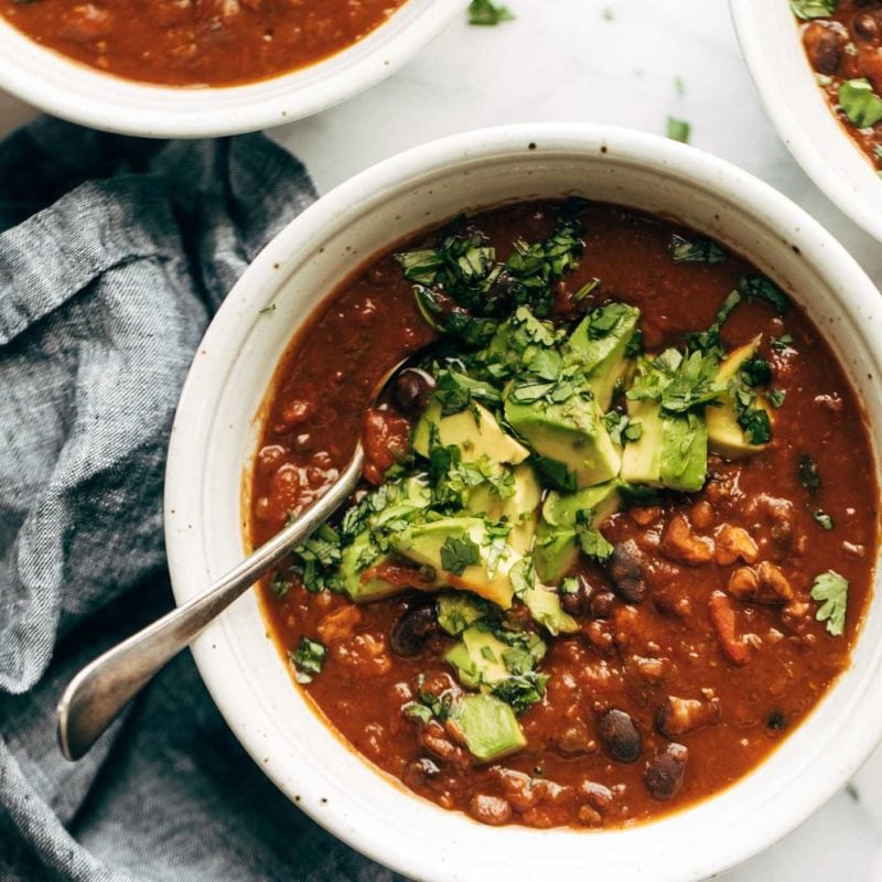 Chili in a bowl with a spoon and toppings.