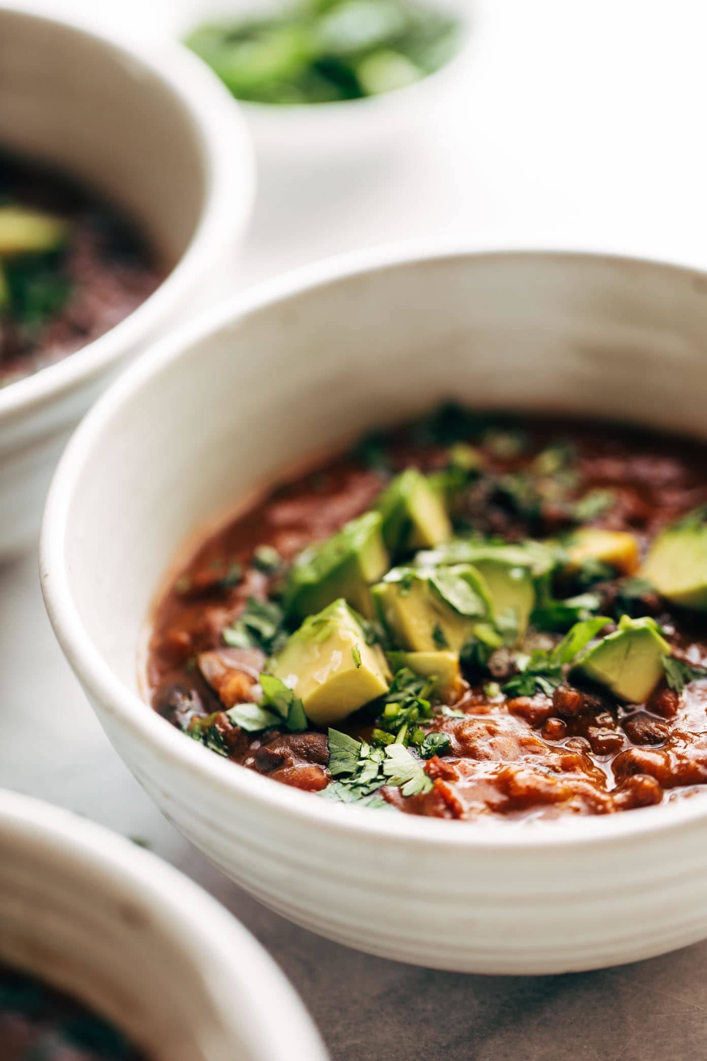 Vegan instant pot chili in a bowl with avocados.